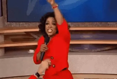 Oprah handing out gifts to her audience and pointing wildly